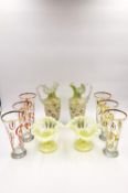 A pair of hand blown satin glass ewers with frilled rims, hand painted with floral decoration, along