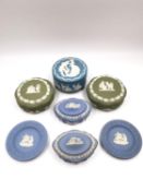 A collection of blue and green Wedgwood Jasperware trinket boxes and dishes with white press-moulded