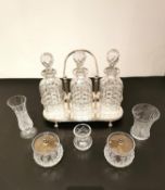 A silver plate tantalus with a swing handle and three cut glass decanters, a pair of silver plate