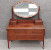 An Edwardian mahogany dressing table with an oval crossbanded swing mirror, above an inlaid top