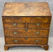 An early Georgian burr walnut bureau with fall front, opening on to a fitted interior above two