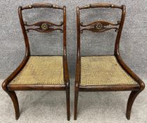 A pair of Regency simulated rosewood and cane seated chairs, carved with fluted decoration and