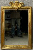 A 19th century giltwood mirror with a carved cresting to the top and moulded foliate decoration to