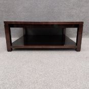 A contemporary coffee table with a polished and stained finish, with two pull out extending