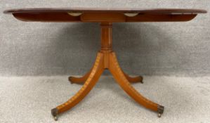 A contemporary Regency style mahogany and satinwood crossbanded dining table, raised on a turned