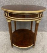An Empire style burr walnut two-tiered lamp/occasional table with ebony inlay and a brass trim,