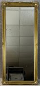 A contemporary wall mirror in silvered foliate frame with bevelled plate. H.167 W.76cm