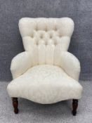 A contemporary Victorian style armchair in deep buttoned foliate upholstery. H.85cm.