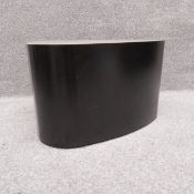 A rounded triangular patinated steel coffee/side table with a polished concrete top by Stephane