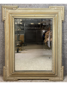 A 19th century carved and distressed framed mirror with a bevel plate. H.106 W.89cm.