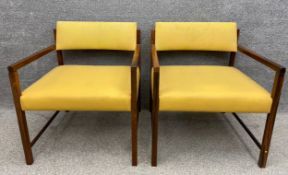 A pair of mid-century hardwood armchairs with yellow faux leather upholstery. H.76cm.