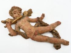 An indistinctly signed naive style painted ceramic figure of a cherub. L.34cm.