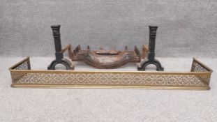 A pierced brass fire kerb, along with a cast iron fire grate, and a pair of cast iron fire dogs of