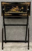 A 19th century chinoiserie lacquered and gilt foldout writing desk, hand painted with a central bird
