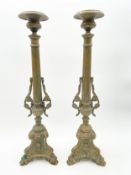 A pair of 19th century brass candlesticks with fluted stems flanked by grape and vine sprigs, on