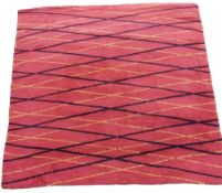 A large mid-century woollen rug with crosshatched black and yellow stripes on a red ground. L.290
