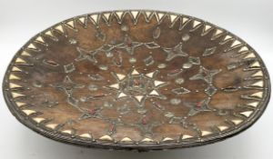 A large Moroccan/North African/Berber carved hardwood bowl clad in embossed white metal and inset