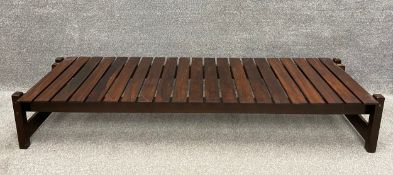 A mid-century teak coffee table with slats across two rails, on stretchered supports. H.31 W.178 D.