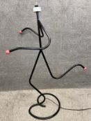A 1950's running man figural lamp made from steel tubing with bakelite terminals, as illustrated