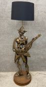 A Spanish folk art style figural hammered and applied steel floor lamp with shade. H.149cm.