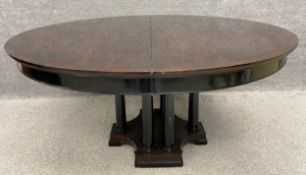 A 19th century style crossbanded extending dining table with a bifold integrated leaf, raised on six
