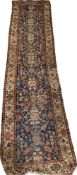 A Persian silk runner with an all over foliate design over a deep blue field, with a complementary