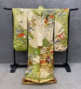 A ceremonial Kimono with embroidered floral decoration on an abstract landscape, along with a