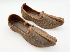 A pair of 19th century Eastern leather shoes, intricately hand embroidered with spirals and