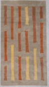 A hand knotted contemporary woollen rug in muted colours with irregular mustard, orange and brown