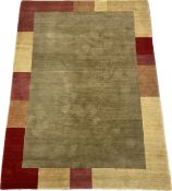 A Nepalese hand made rug with a minimal central bronze field surrounded by a border of abstract