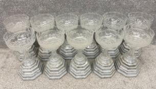 A collection eleven footed glass floristry vases/bowls on simulated stone stepped plinth bases. H.