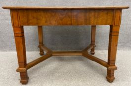 A 19th century Biedermeier style walnut extending table with two integrated leaves and draw leaf