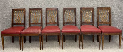 A set of six French C.1900 stained pine dining chairs each with a gilt overlapping spindle back