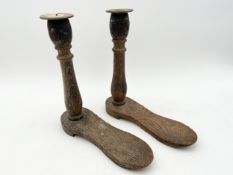 A pair of unusual oak candlesticks with brass holders on turned stems with shoe-shaped bases. H.24