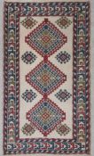 A Turkish Kilim rug with three central geometric lozenge medallions in crimson red, sapphire blue