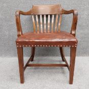 An early 20th century mahogany office desk chair with leather and stud-work upholstery on square
