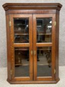 A Victorian oak corner cabinet with a moulded cornice above a crossbanded mahogany frieze over two
