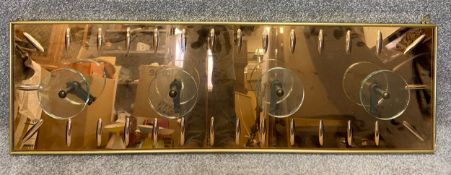 An Art Deco style polished copper and glass coat rack in a brass frame with a repeating moulded