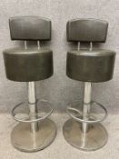 A pair of mid-century chrome and faux leather bar stools with a swivel action. H.108cm.