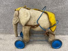 An early 20th century stuffed ride on elephant in the manner of Stieff. H.46 W.54 D.24cm.