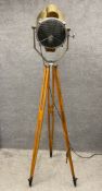 An early to mid 20th century brass floor standing spot lamp on adjustable teak tripod supports. H.