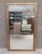 An early to mid 20th century gilt metal mirror with allover neoclassical style cast scrolling