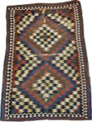 A handmade Qashqai Kilim rug with two geometric lozenges over an iron red ground. H.216 W.149cm.