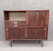 A mid-century highboard drinks cabinet having a recessed alcove over two short drawers beside a