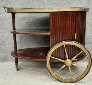 An Art Deco mahogany drinks trolley/bar cart, the egg shaped top having a pierced brass rail trim