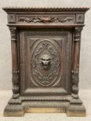 A Victorian carved oak side cabinet with a carved top above a single frieze drawer with a