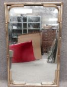 A 1970's vintage brass effect mirror with a stylised simulated bamboo tubular metal frame. H.89 W.