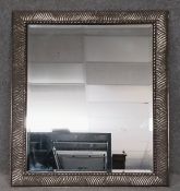 A large contemporary mirror with a carved gilt frame and a bevelled plate. H.100 W.80cm