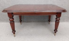 A contemporary William IV style mahogany extending dining table with a moulded top over four heavy