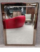 A mid to late 20th century wall hanging mirror with a rectangular bevelled plate mounted on a smoked